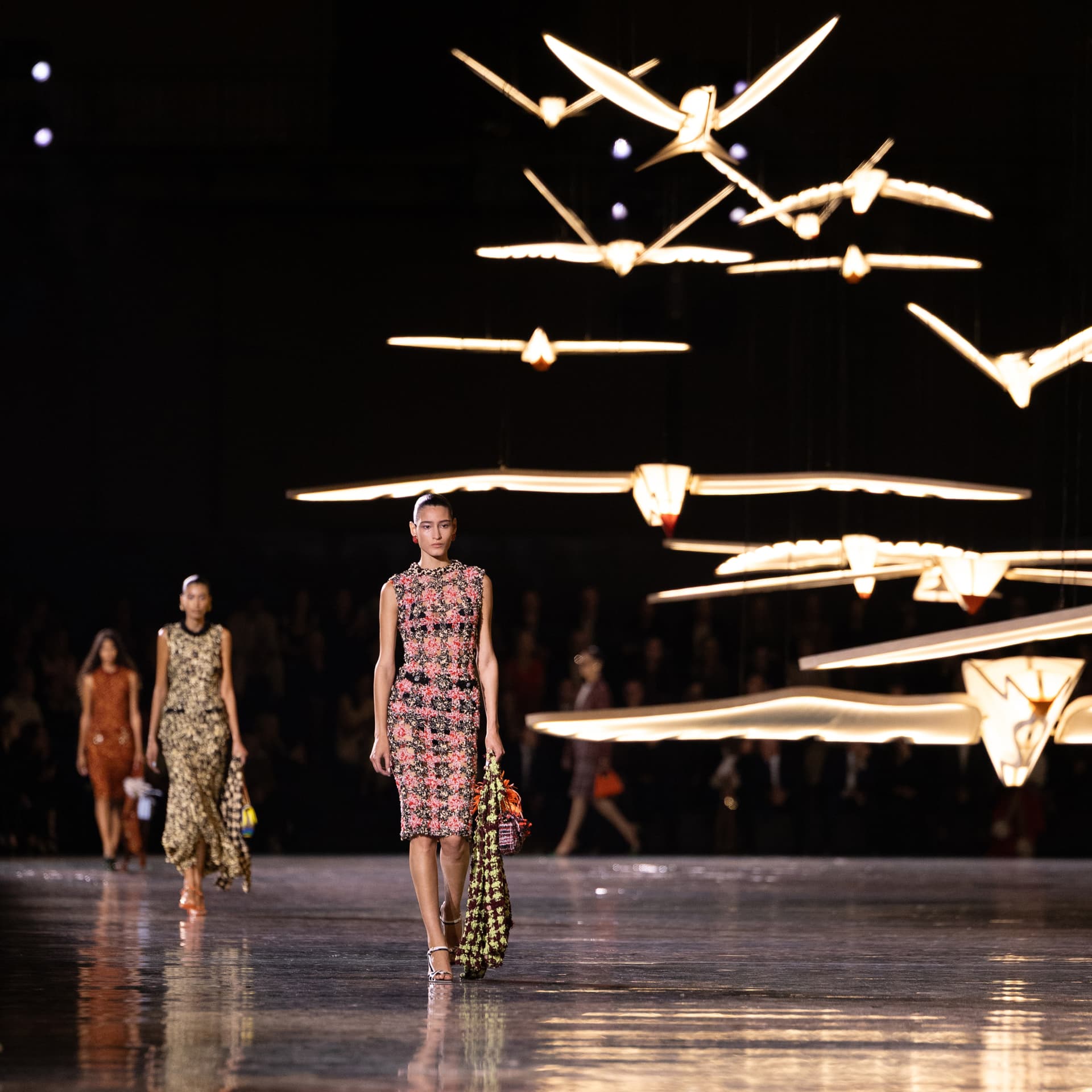 Mannequin Chanel en robe de tweed sous les oiseaux lumineux