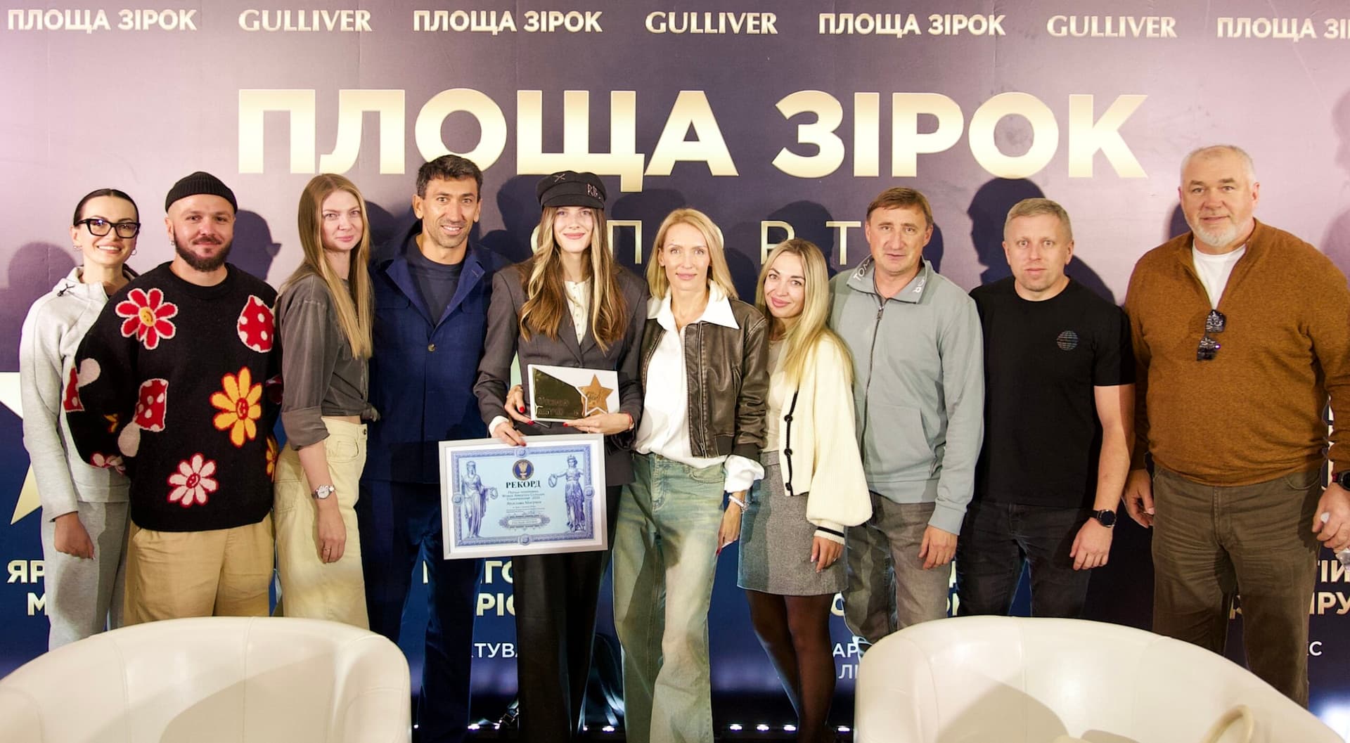 Yaroslava Mahuchikh, en casquette, tient son étoile et un diplôme de record parmi les invités devant la bannière de la « Place des étoiles »