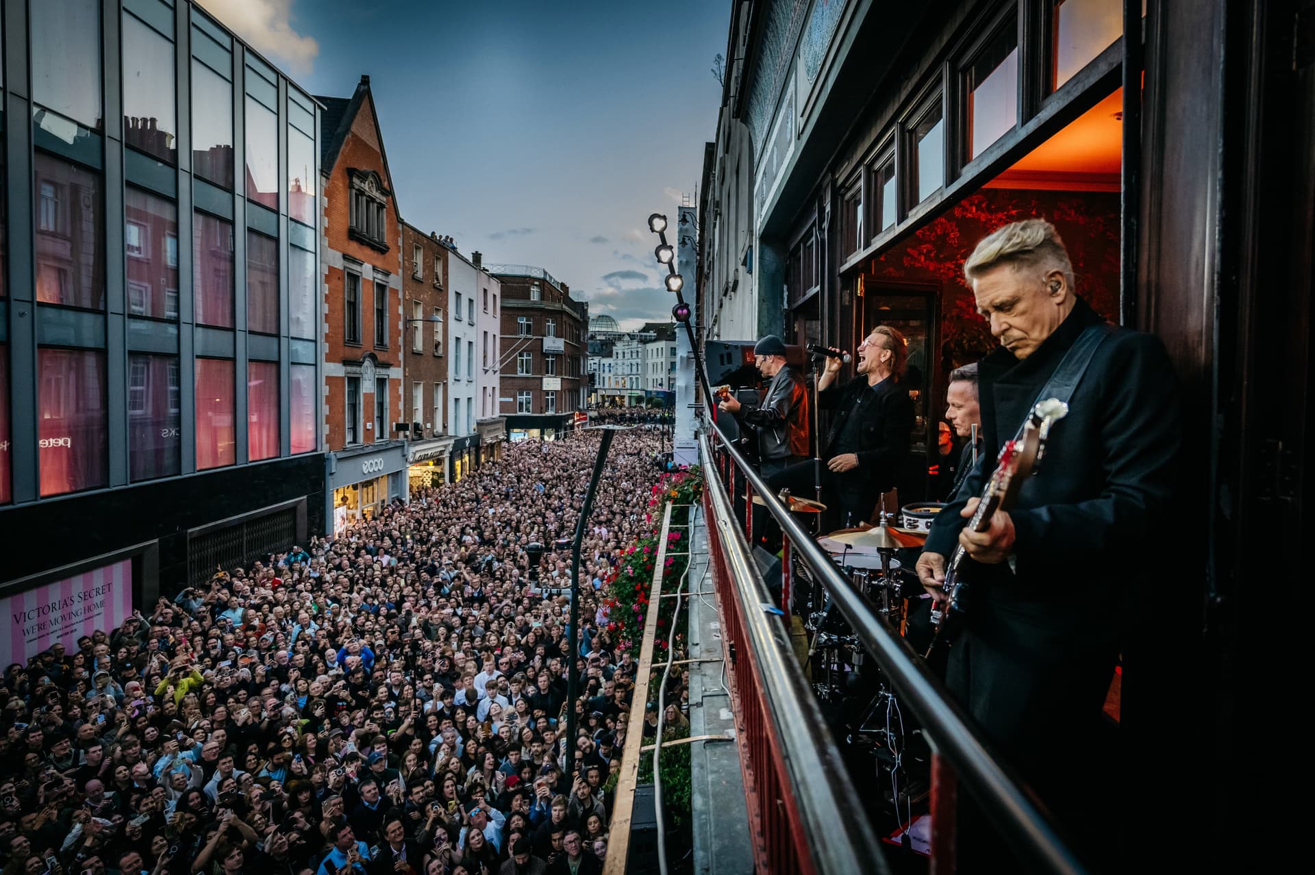 Le groupe U2 joue au balcon du café Bewley’s au-dessus de Grafton Street noire de monde, à Dublin