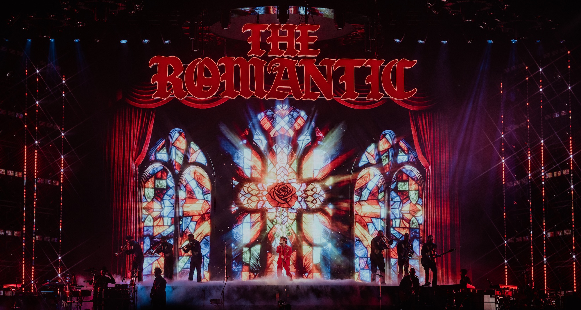 Сцена туру The Romantic: величезні вітражі з червоною трояндою, напис THE ROMANTIC і музиканти в диму