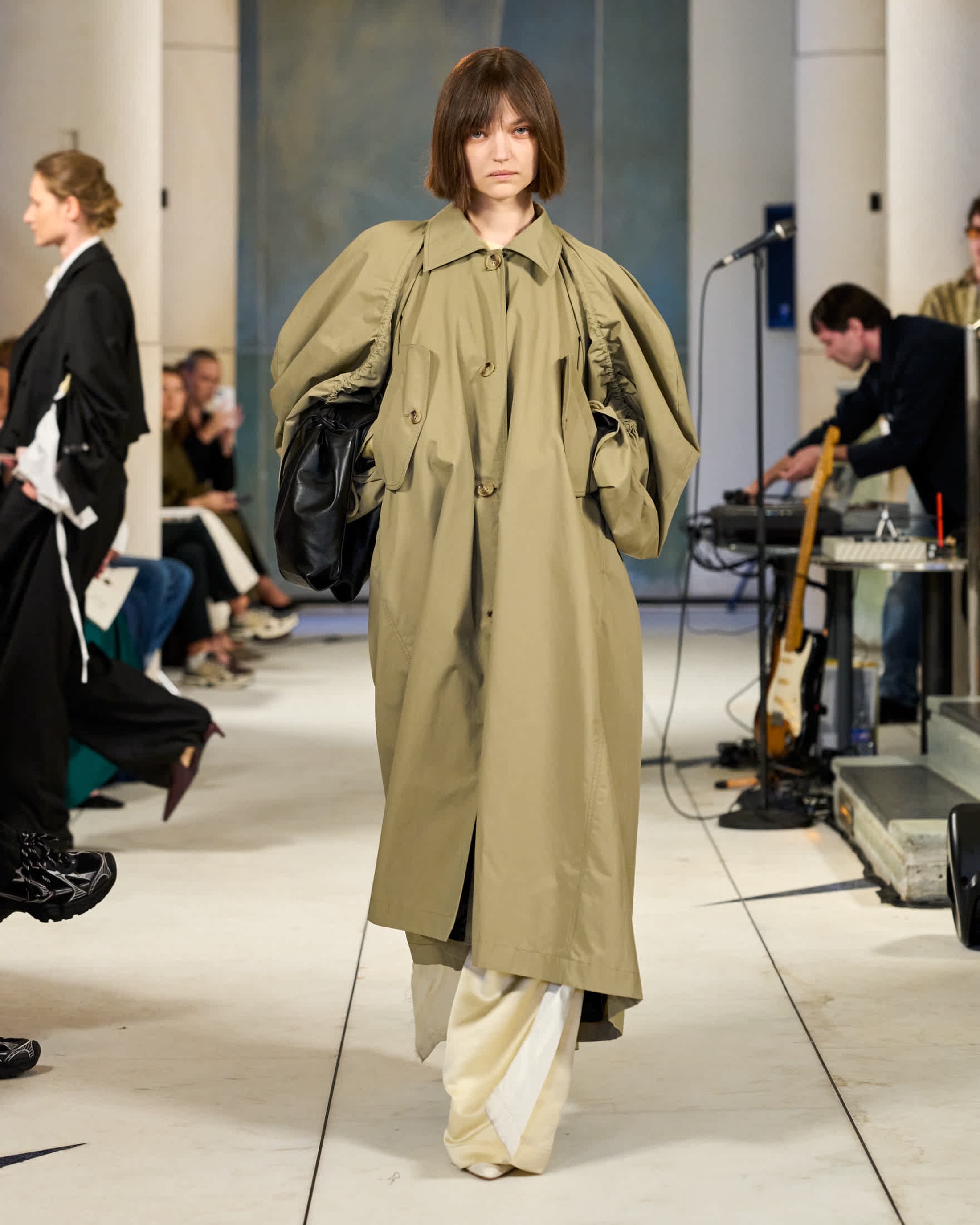 Mannequin en trench olive au défilé Litkovska