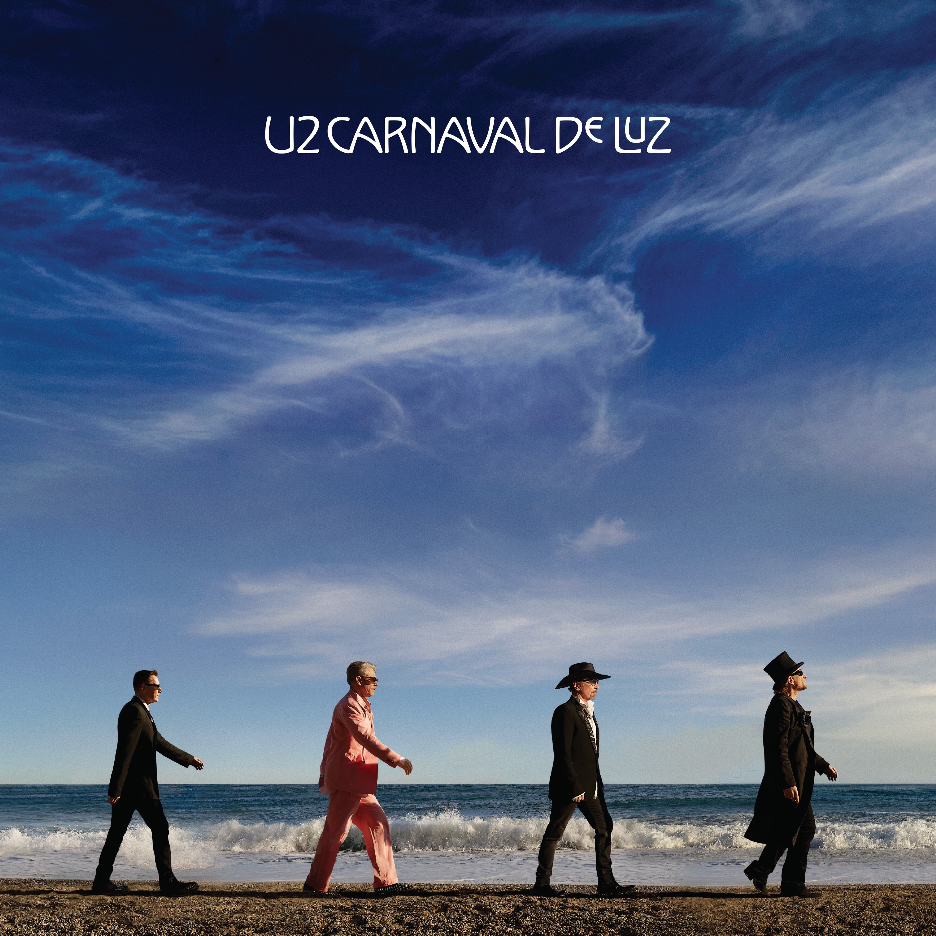 Pochette de l’album Carnaval De Luz de U2 : quatre musiciens marchent au bord de la mer sous un ciel bleu