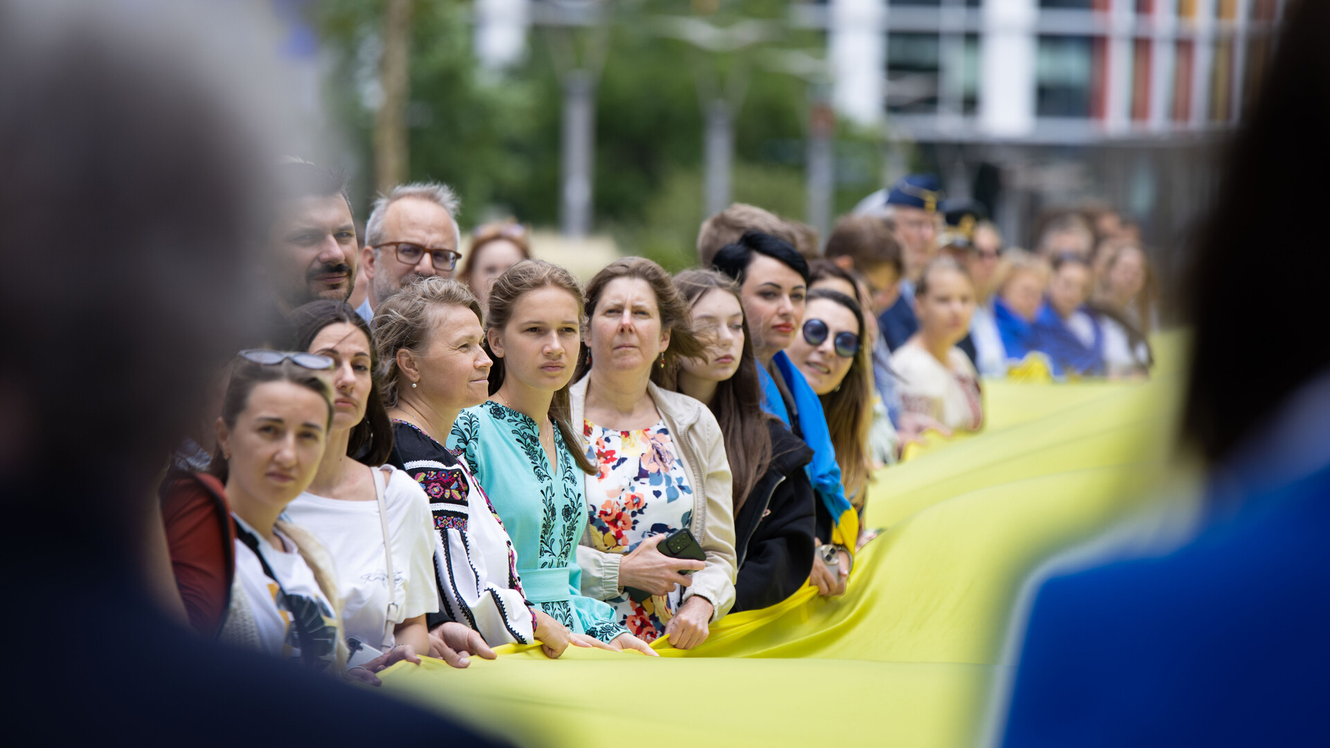 Люди тримають розгорнутий велетенський прапор України на святкуванні